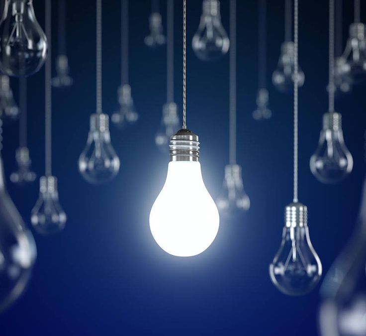 Foco encendido colgando entre focos apagados sobre fondo azul